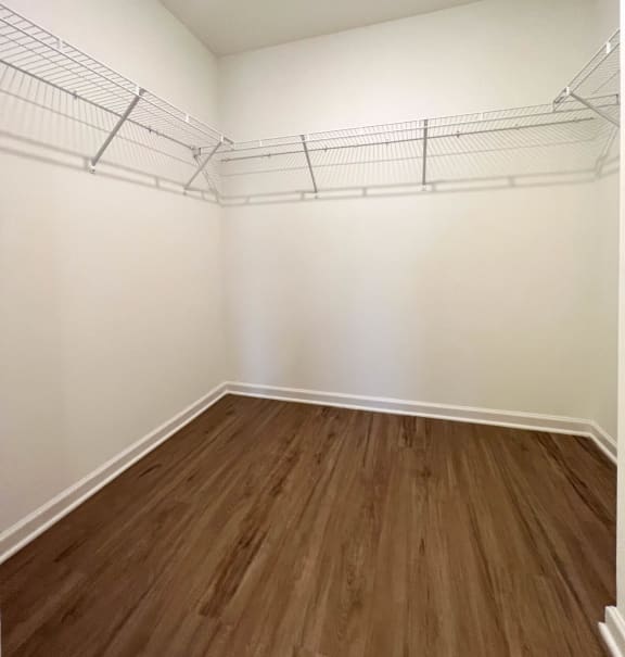an empty bedroom with white walls and wood floors