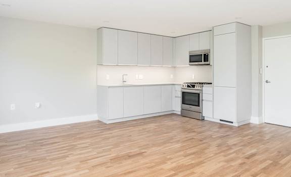 Open concept dining and living rooms with hardwood floors and ample natural light