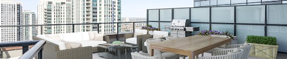 A patio with a table and chairs overlooking a cityscape.