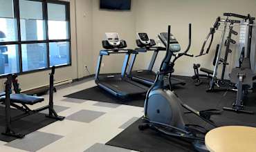 A gym with treadmills, elliptical machines, and other exercise equipment.