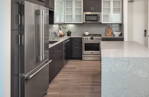 a kitchen with stainless steel appliances and white counter tops