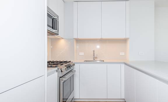 A kitchen with white cabinets and appliances.