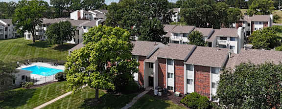 A large apartment complex with multiple buildings and a parking lot in front.