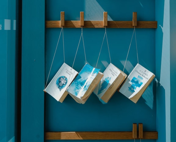 a display of books hanging on a blue wall
