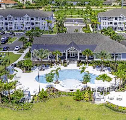 A large resort with a pool and palm trees.