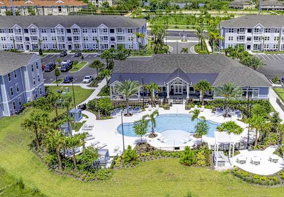 A large resort with a pool and palm trees.