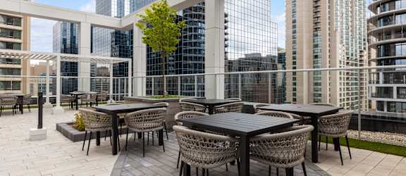 a patio with tables and chairs on top of a building