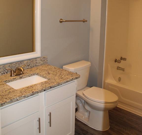 A bathroom with a toilet, sink, and shower.