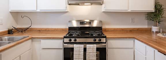 A modern kitchen with white cabinets and a stainless steel refrigerator.