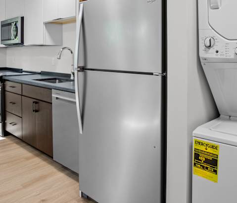 a white kitchen with a washer and dryer and a window