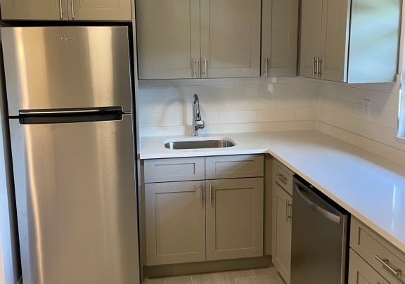 a kitchen with grey cabinets and white countertops