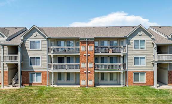 Apartment building with balconies and multiple windows.