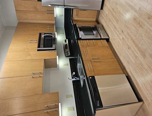 A modern kitchen with wooden cabinets and a black countertop.