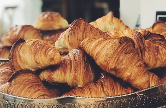 a pile of croissants in a silver bowl