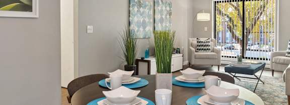 A dining room with a table set for four.