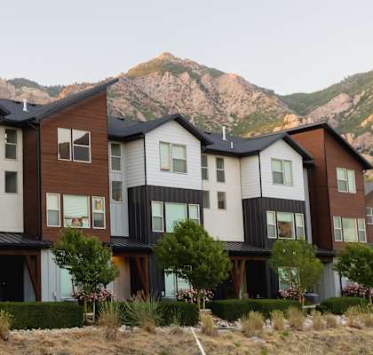 A row of modern houses with a mountain in the background.