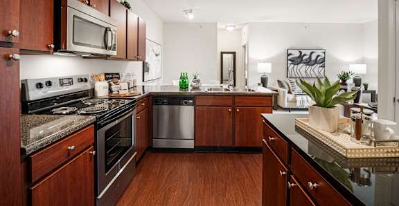 A kitchen with dark wood cabinets and a black counter top.