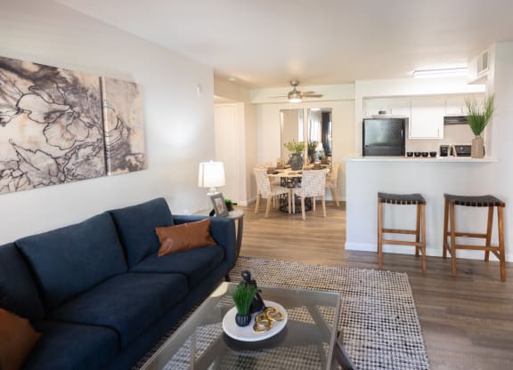 a living room and kitchen with a blue couch and a coffee table at Austin Crest Apartments, Reno, Nevada