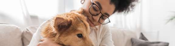 A person is hugging a small dog.