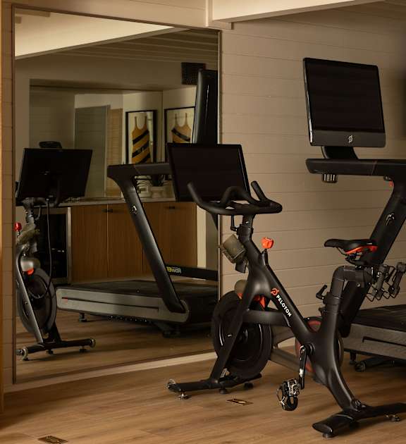 A room with a treadmill, a stationary bike and a computer monitor at The PARKER on E Mulberry Apartments, Texas