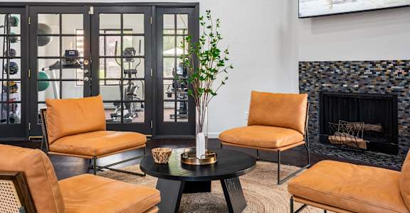 A living room with a fireplace and a painting of giraffes on the wall.