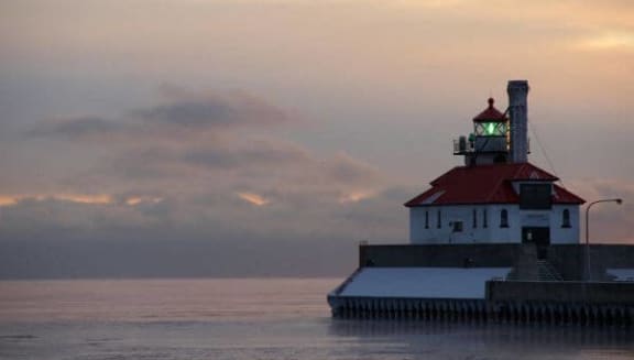 a lighthouse on a pier in the middle of the ocean