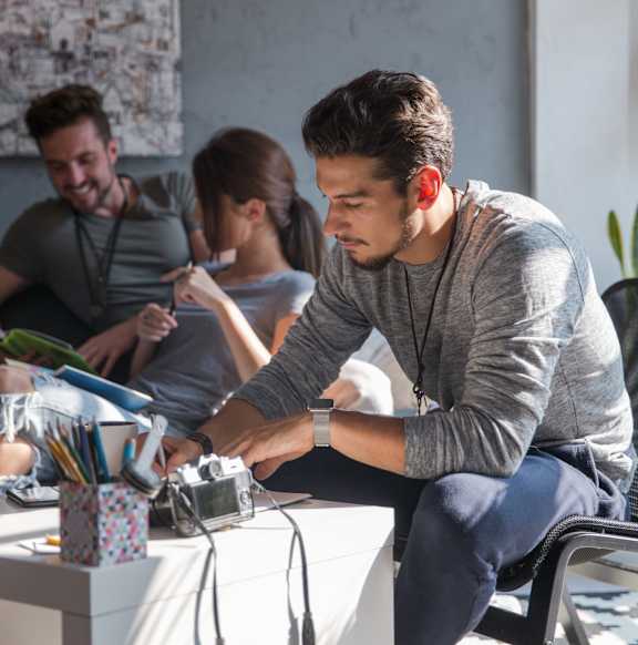 A man is sitting at a table and appears to be working on a project.