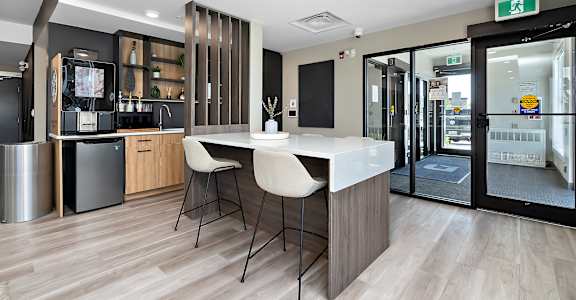 A modern kitchen with a bar area and a dining table.