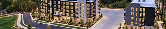 A modern apartment complex with a parking lot in front.