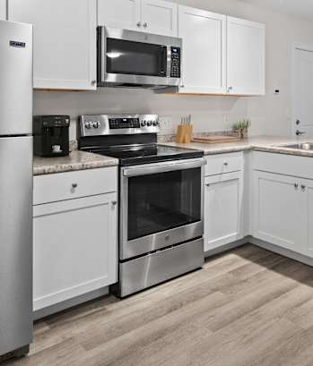a kitchen with stainless steel appliances and white cabinets