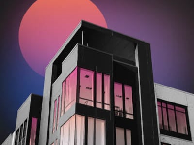 A building with a large pink and orange sun in the background.