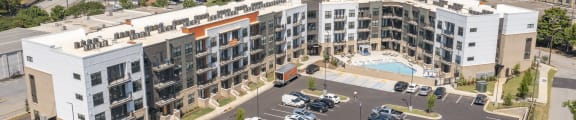 an aerial view of a large parking lot with several apartment buildings and a swimming pool at The Fitzgerald in Spartanburg, SC 29302