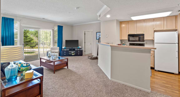 a living room with a kitchen in the background