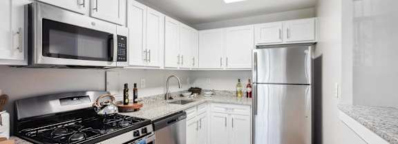 a kitchen with stainless steel appliances and white cabinets