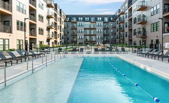 an apartment swimming pool in front of an apartment building