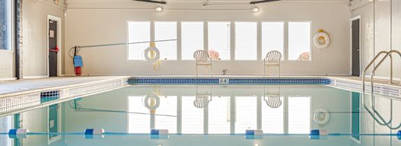 A large indoor swimming pool with a diving board.