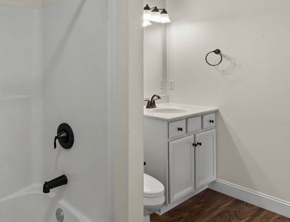 A white bathroom with a walk-in shower and a white sink.