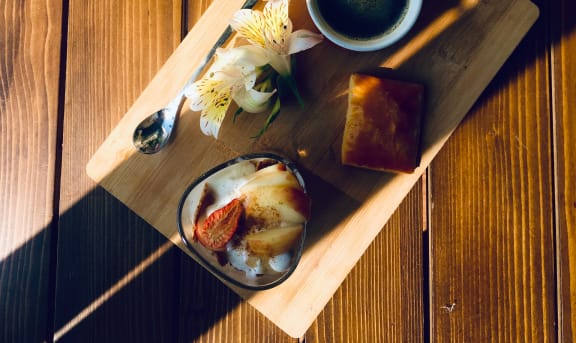 a plate of food and a cup of coffee on a wooden table
