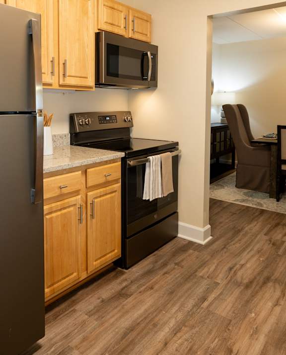 A kitchen with wooden cabinets and a black refrigerator  at Ivy Hall Apartments*, Maryland, 21204