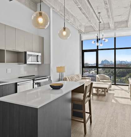A modern kitchen with a large island and a view of the city.