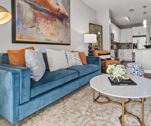 A blue couch with a white table in front of it.