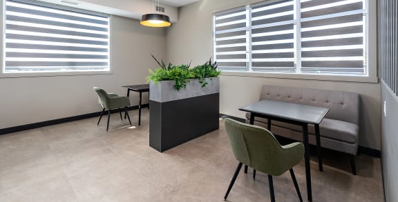 a seating area with tables and chairs and a potted plant