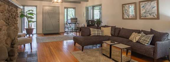 A living room with a stone fireplace and a large couch.