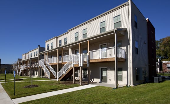 the exterior of an apartment building with stairs and balconies