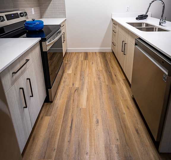 a kitchen with wooden floors and stainless steel appliances
