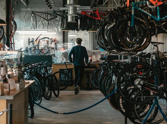 a man is walking through a bike shop filled with bikes