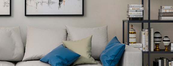 A modern living room with a white sofa, a coffee table, and two abstract paintings on the wall at Stone Loch Apartments, TX 77375