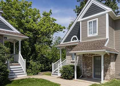 the front of a house with a sidewalk and a lawn