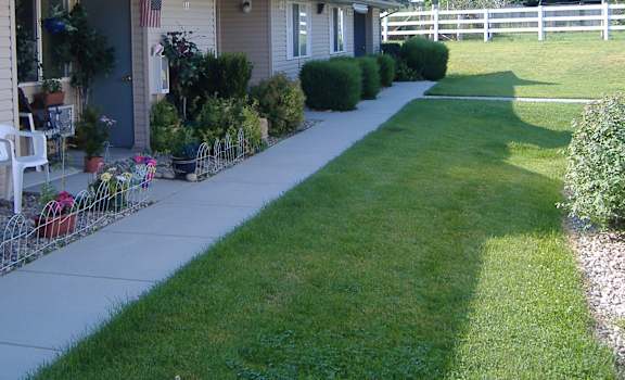 Image of exterior of building, plants, and lawn