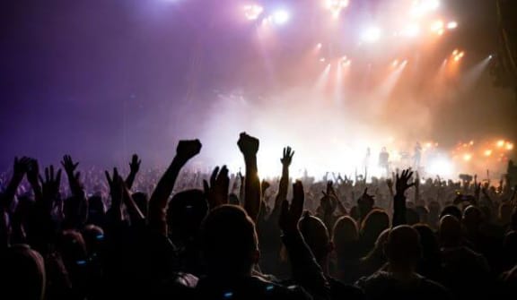 a crowd of people with their hands in the air at a concert